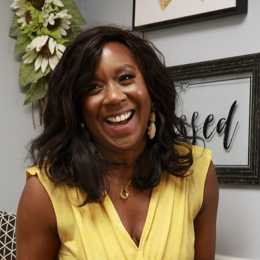 A woman wearing a yellow dress and smiling